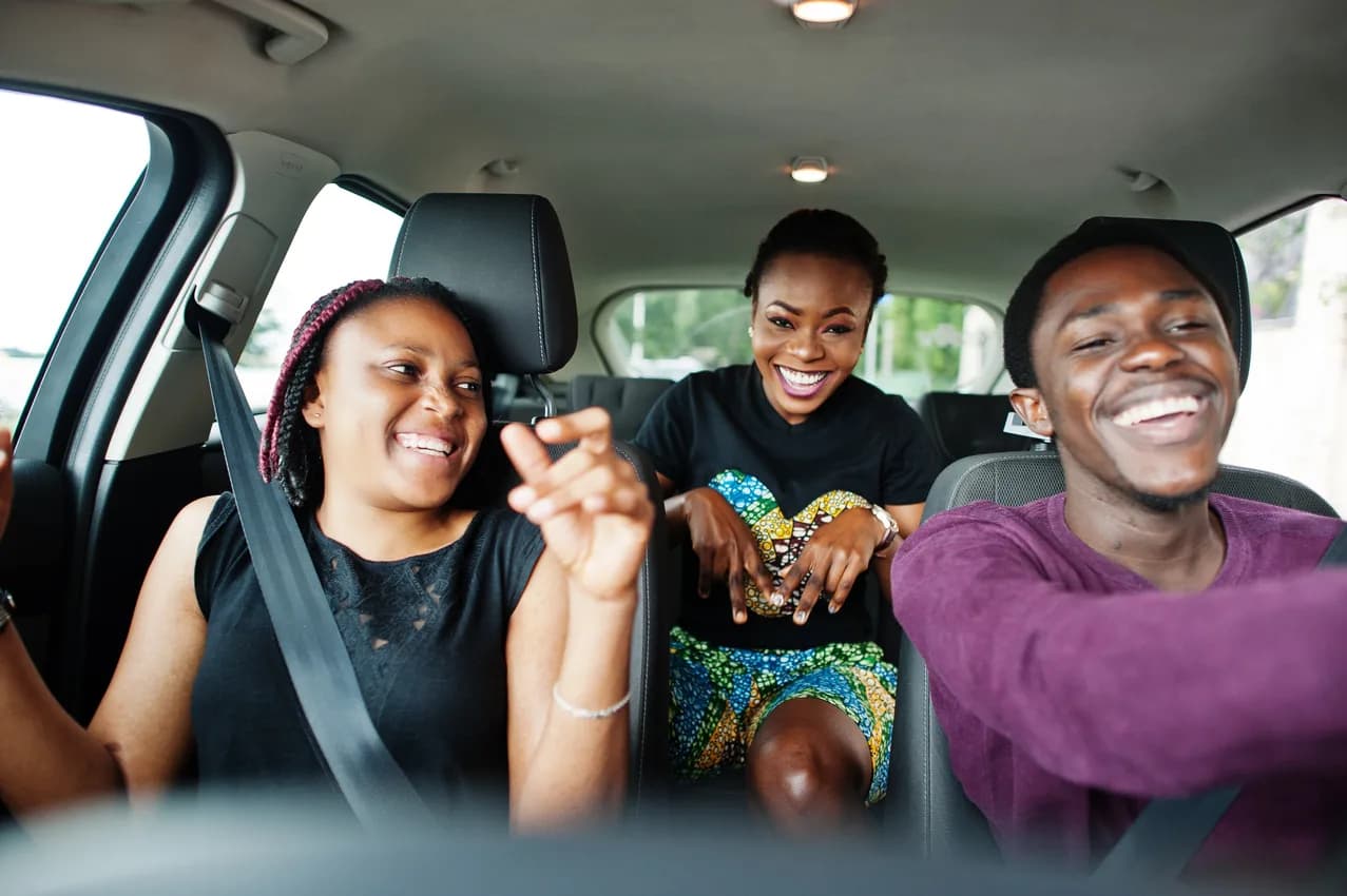 A family laughing together in a car, settled and comfortable